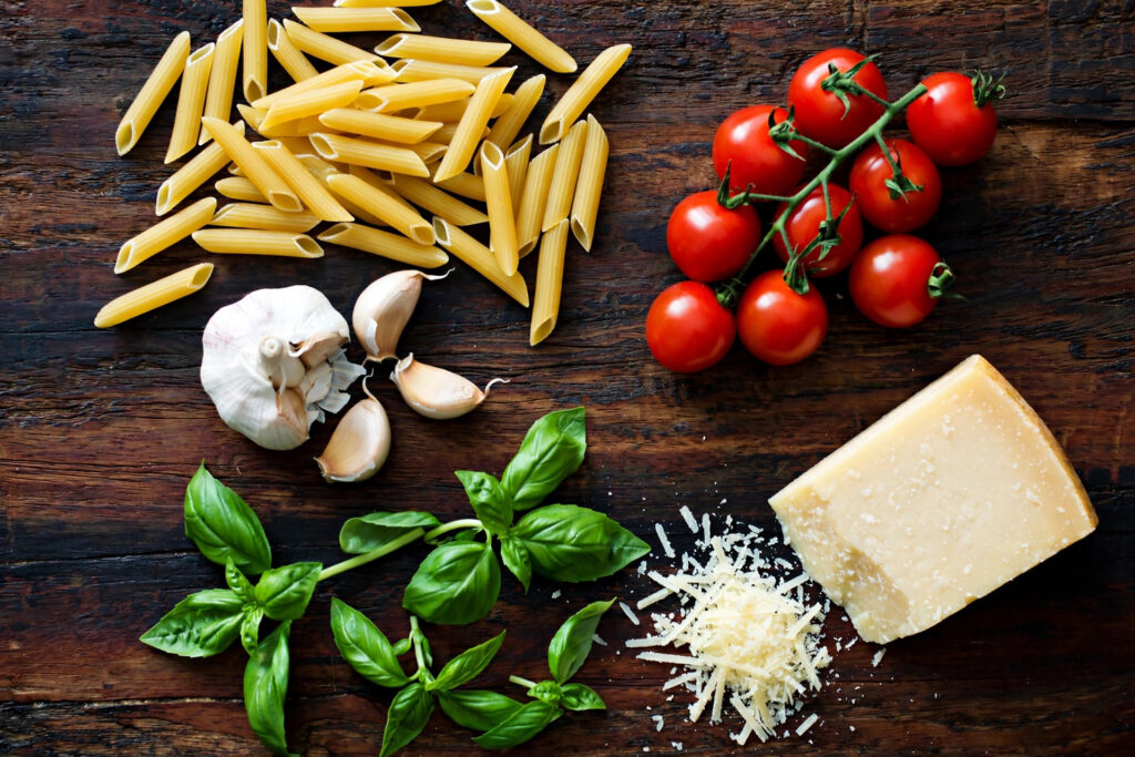 One-pot pasta ingredients: dry pasta, cherry tomatoes, garlic, basil and parmesan